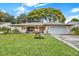 Brick ranch home with mature landscaping and a two-car garage at 8809 Shoemaker Ln, Hudson, FL 34667