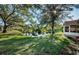 Backyard with pond view, lush landscaping, and large trees at 9338 Clearmeadow Ln, New Port Richey, FL 34655