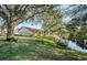 Landscaped backyard with pond, large trees, and bird bath at 9338 Clearmeadow Ln, New Port Richey, FL 34655