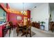 Dining room with a wooden table and chairs, and a red accent wall at 9338 Clearmeadow Ln, New Port Richey, FL 34655