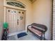 Front entry with double doors, wicker bench, and a welcome mat at 9338 Clearmeadow Ln, New Port Richey, FL 34655