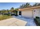Tan brick house exterior with a two-car garage and landscaping at 9338 Clearmeadow Ln, New Port Richey, FL 34655