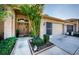 Brick house exterior with double doors, a two-car garage, and lush landscaping at 9338 Clearmeadow Ln, New Port Richey, FL 34655