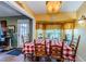Charming kitchen nook with a checkered tablecloth, wood table and chairs, and window views at 9338 Clearmeadow Ln, New Port Richey, FL 34655