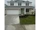 Two-story home with light gray siding, stone accents, and a teal door at 10126 Zennia Ln, Parrish, FL 34219