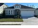 One-story home with gray siding, stone accents, and a two-car garage at 10131 Zennia Ln, Parrish, FL 34219