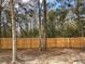 Backyard with wooden fence and mature trees providing shade at 11743 Purdue St, New Port Richey, FL 34654