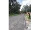 Gravel driveway leading to a home with trees and vegetation on either side at 11743 Purdue St, New Port Richey, FL 34654