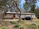 Single-wide manufactured home with a car parked in front and mature trees surrounding the property at 11743 Purdue St, New Port Richey, FL 34654