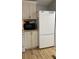White refrigerator and light wood cabinets in a compact kitchen at 11743 Purdue St, New Port Richey, FL 34654