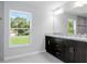 Double vanity bathroom with granite countertop and dark wood cabinets at 12040 Pine Warbler Ave, Brooksville, FL 34614