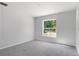 Bright bedroom with carpeted floor and a large window at 12040 Pine Warbler Ave, Brooksville, FL 34614
