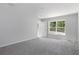 Well-lit bedroom featuring grey carpet and a window with a view at 12040 Pine Warbler Ave, Brooksville, FL 34614