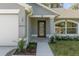Front entryway with a modern black door, and a landscaped walkway leading to the home at 12040 Pine Warbler Ave, Brooksville, FL 34614