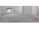 Spacious living room with gray carpet, a large window, and access to other rooms at 12040 Pine Warbler Ave, Brooksville, FL 34614