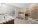 Bathroom with double sinks, a soaking tub, and a walk-in shower at 12307 Duckett Ct, Spring Hill, FL 34610