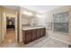 Double vanity bathroom with a view into the main bedroom at 12307 Duckett Ct, Spring Hill, FL 34610