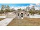Tan house with a green door and attached garage at 12312 Millington Ave, Weeki Wachee, FL 34614