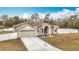 Tan house with green door and attached garage at 12312 Millington Ave, Weeki Wachee, FL 34614