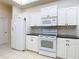 Kitchen boasts white cabinets, black countertops, and a full suite of appliances at 12312 Millington Ave, Weeki Wachee, FL 34614