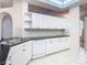 White kitchen with granite countertops and a built in dishwasher at 12312 Millington Ave, Weeki Wachee, FL 34614