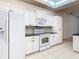 White kitchen with black countertops and stainless steel appliances at 12312 Millington Ave, Weeki Wachee, FL 34614