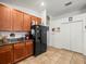 Kitchen features wood cabinets, granite countertops, and a black refrigerator at 14284 Finsbury Dr, Spring Hill, FL 34609