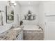 Bathroom with granite vanity, soaking tub, and decorative art at 2013 Gulfview Dr, Holiday, FL 34691