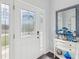 Bright entryway with white door, stained-glass accents, and decorative console table at 2013 Gulfview Dr, Holiday, FL 34691