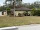 House exterior with tan colored walls, brown roof, and landscaping at 3039 Sandpiper Ct, Clearwater, FL 33762
