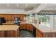 Spacious kitchen with wood cabinets, tile countertops, and a view of the pool at 4412 Lake In The Woods Dr, Spring Hill, FL 34607