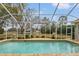 Inviting screened pool with a tranquil view at 4412 Lake In The Woods Dr, Spring Hill, FL 34607