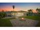 Backyard with fire pit and patio area at sunset at 4424 Floramar Ter, New Port Richey, FL 34652