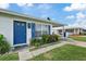 Front entrance of a charming home with a blue door and landscaped yard at 4424 Floramar Ter, New Port Richey, FL 34652