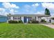 Charming one-story home with blue door and landscaped yard at 4424 Floramar Ter, New Port Richey, FL 34652