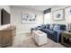 Cozy bonus room with blue sectional sofa, ottomans, and large artwork at 4515 Spire Run, Lakewood Ranch, FL 34211