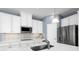 Modern kitchen features white cabinets, stainless steel appliances, and patterned backsplash at 4515 Spire Run, Lakewood Ranch, FL 34211