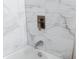 Clean bathroom with wave patterned marble tile and updated fixtures at 4852 Capron St, New Port Richey, FL 34653