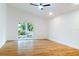 Bright bedroom with wood floors, sliding door to backyard, and ceiling fan at 4852 Capron St, New Port Richey, FL 34653