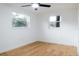 Simple bedroom with wood floors and two windows at 4852 Capron St, New Port Richey, FL 34653