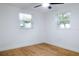 Simple bedroom with wood floors and two windows at 4852 Capron St, New Port Richey, FL 34653