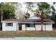 White single story home with brown trim, covered porch, and palm tree at 4852 Capron St, New Port Richey, FL 34653