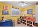 Small bedroom with yellow walls and built-in storage at 4907 Floramar Ter, New Port Richey, FL 34652