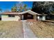 Tan single story home with brick entryway and walkway at 5641 Quist Dr, Port Richey, FL 34668