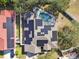 Aerial view of house featuring solar panels and a screened-in pool at 609 Salt Lake Dr, Tarpon Springs, FL 34689