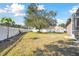 Landscaped backyard featuring a large tree and a white fence at 609 Salt Lake Dr, Tarpon Springs, FL 34689