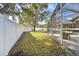 Spacious backyard with grassy area and white vinyl fence at 609 Salt Lake Dr, Tarpon Springs, FL 34689