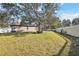 Private backyard with a large tree and grassy area at 609 Salt Lake Dr, Tarpon Springs, FL 34689