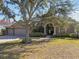 House exterior features a large front yard, double garage, and mature tree at 609 Salt Lake Dr, Tarpon Springs, FL 34689