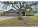 Gray house with double doors and large tree in front at 609 Salt Lake Dr, Tarpon Springs, FL 34689